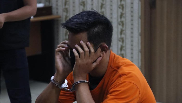 Pria tersangka pelecehan di pesawat tertunduk mengenakan baju tahanan oranye